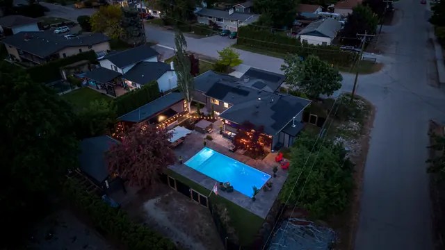 Aerial view twilight pool, modern home with pool in Glenmore, Kelowna, BC. Real estate photography by Pixel Pro Productions.