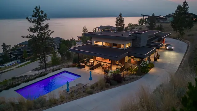 Aerial view pool twilight, luxury lake-view home in Lakestone, Lake Country, BC. Real estate photography by Pixel Pro Productions.